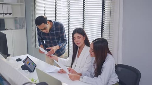 Asian young businessman and businesswoman working in the office.