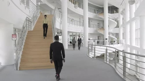 People Walking in Modern Building Lobby Wearing Masks