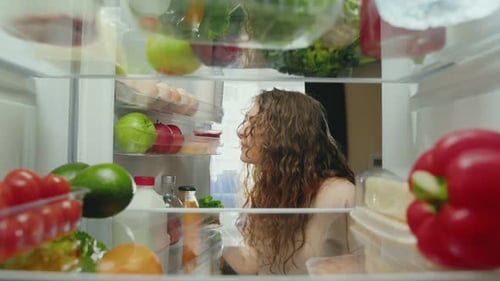 Woman Grimaces at Old Meat Inside Refrigerator