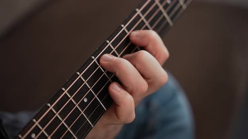 Hand Plays Chords on Acoustic Guitar Neck Close-up