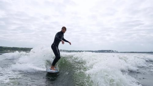 Surfer Skillfully Rides a Wave Showcasing Balance and Agility in Dynamic Water Scene