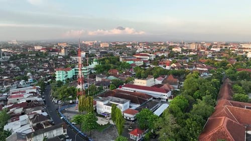 Luftaufnahme eines Wohnhauses in der Stadt Yogyakarta bei Sonnenuntergang mit Blick auf den Berg Merapi, Indonesien.
