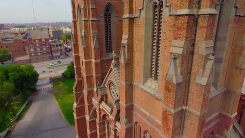 Close up aerial view of A beautiful old Church, A cross on the Church building, Traffic is moving on