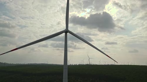Wind turbine spinning generating clean green energy, drone point view. Windmill rotating at wind far