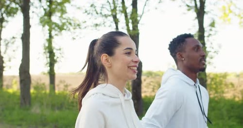 Nahaufnahme multiethnischer Sportler, Männer und Frauen, die gemeinsam auf der Straße vor der Stadt laufen