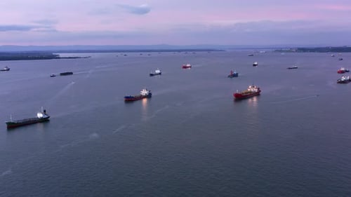 Coast full of Oil and LPG Tankers in the evening - Aerial shot - Port of Balikpapan city - Indonesia