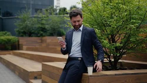 Man in Suit Uses Cellphone Outdoors