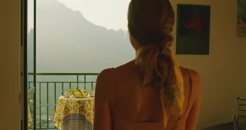 Woman Takes Photo of Mountain View from Balcony