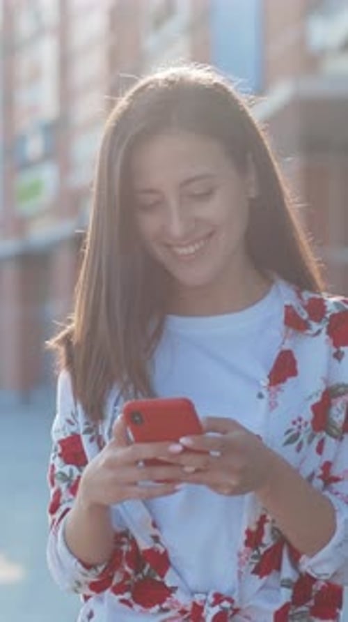 Young Woman Using Smartphone on City Street