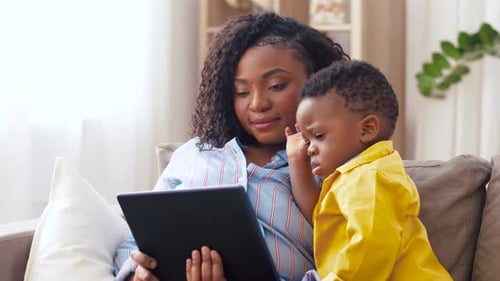 Woman and Child Look at a Tablet