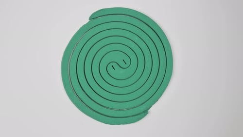 Spirale à moustiques tournant sur un moulinet sur fond blanc