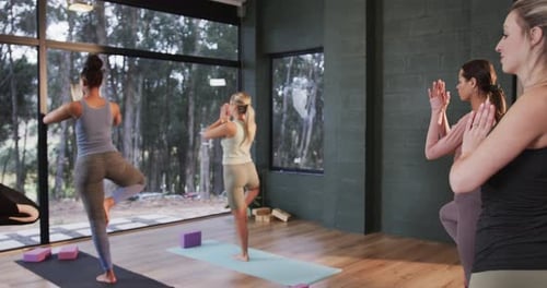 Women Practice Yoga Poses in Serene Studio