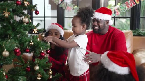 Family Decorates Christmas Tree Together in Home