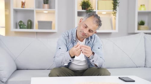 Nachdenklicher Mann mit einem Ring in der Hand. Trennungsgedanke.
