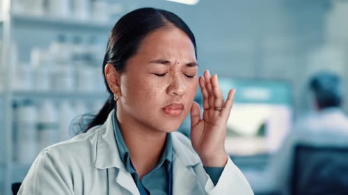 Woman in Lab Coat Rubbing Temples