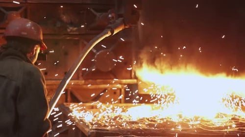 The Worker Skillfully Manages and Oversees Molten Metal in an Industrial Foundry Setting Stock Clip