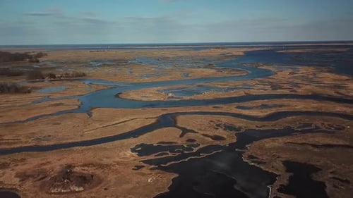 Wide drone aerial of Essex Bay and the Great Marsh, Massachusetts with meandering tidal channels.