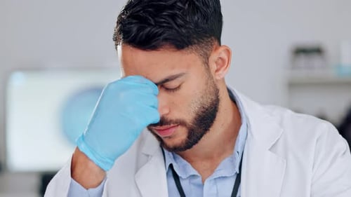 Stressed Scientist Rubbing Forehead in Lab Coat