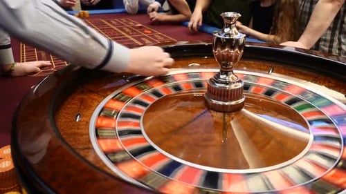 Closeup Shot of Casino Roulette Spinning Around with Casino Chips Put in Piles Near