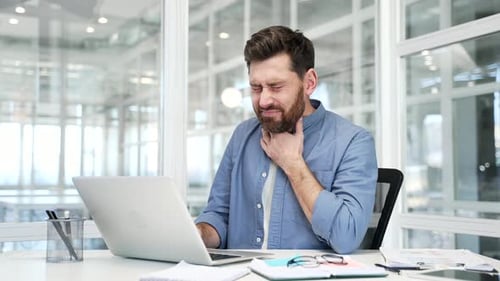 Man Working at Laptop With Sore Throat