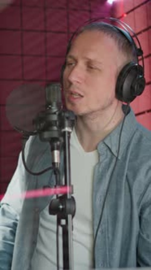Man Singing Passionately in Recording Studio with Acoustic Panel Background