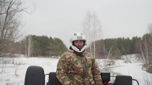 ATV Rider Ready Snowy Trail Offroad Adventure Prep Focused Rider Checks Gear on Snowy Path Caucasian