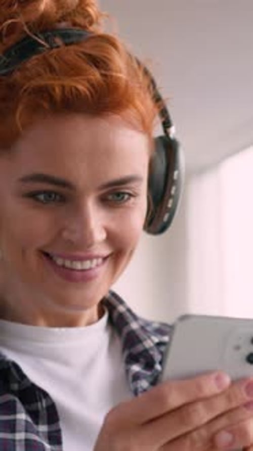 Smiling Woman Listening to Music Holding Smartphone
