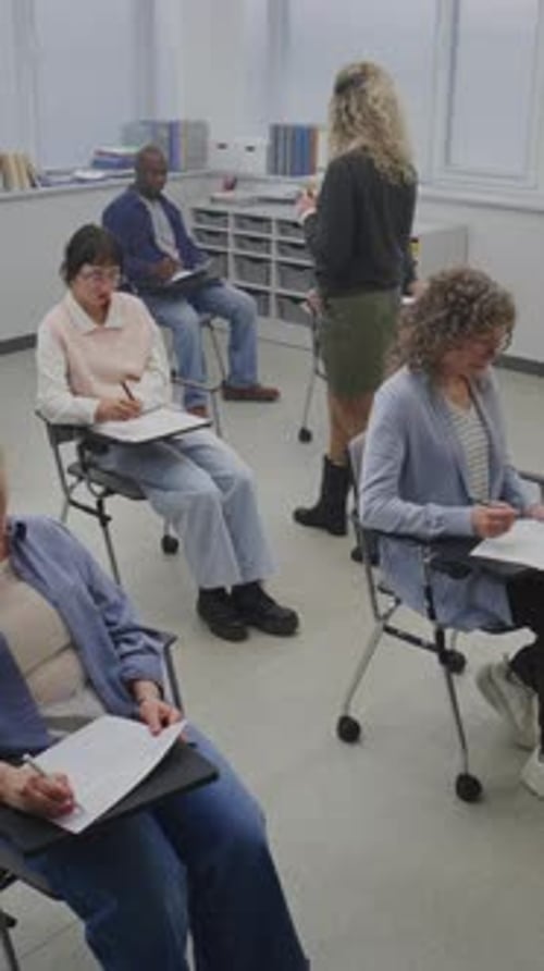 Adults Attending Class, Taking Notes in Classroom