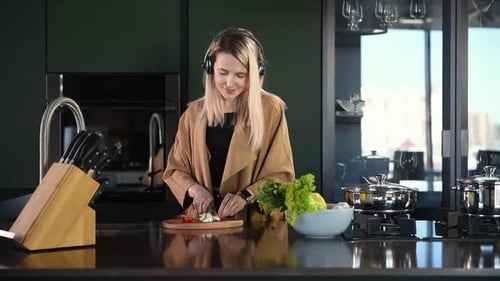 Woman with Headphones Cooking in Modern Kitchen