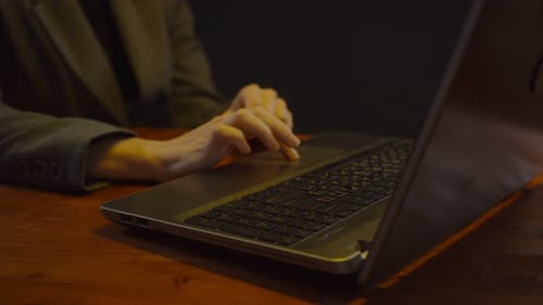 Woman typing at a laptop at night