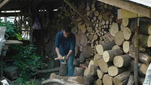 A European Man Chops Firewood with an Ax