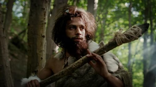 Portrait of Primeval Caveman Wearing Animal Skin and Fur Hunting with a Stone Tipped Spear in the P