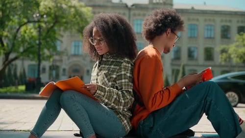 Afrikanische ethnische Studenten Klassenkameraden Freunde Frau Mädchen Weiblicher Mann Männlicher Kerl sitzen außerhalb der Stadt Zurück zu