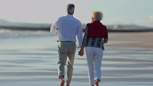 Senior Couple Walking on Beach Enjoying Retirement Together