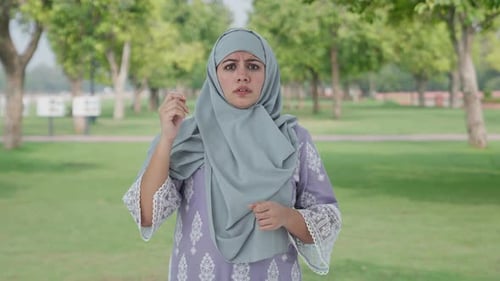 Muslim woman getting a shocking news in park