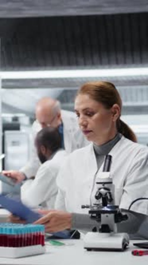 Scientists Working With Microscope and Test Tubes in Lab