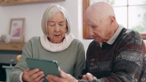 Senior Couple Interacting with Tablet in Home