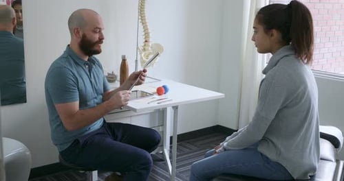 Medical Professional Explains Spine to Patient in Office