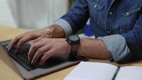 Man Typing on Laptop at Desk in Office