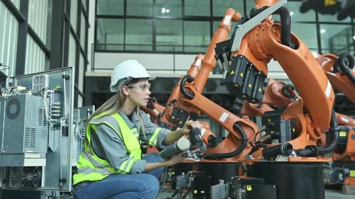 Female Engineer Controls Robotic Arm Machinery in Factory