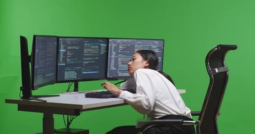 Asian Woman Developer Boring While Write Code With Multiple Computer Screens In Green Screen Studio