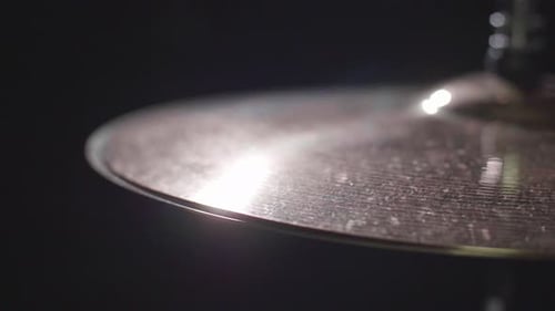 Smooth close up of a drum hi-hat being played with sticks. Super Close up with a dark background. Gi
