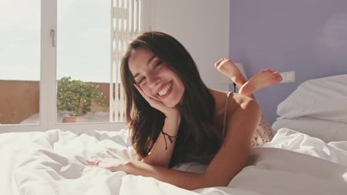 Close-up, happy girl posing lying in bed