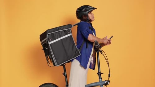 Female Delivery Employee with Bicycle Typing on Phone