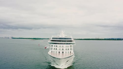 Cruise Ship Leaves the Bay Accompanied By a Towing Boat