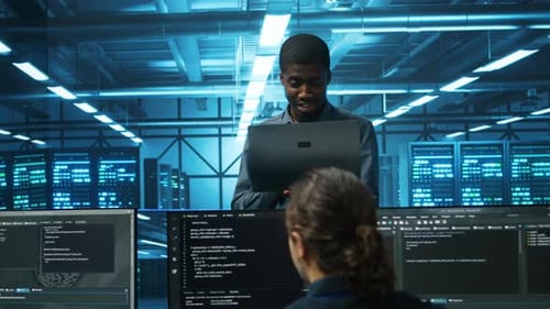 Server Room Technician Collaborates on Laptop