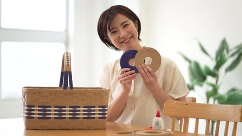 Woman crafting handmade basket at table indoors