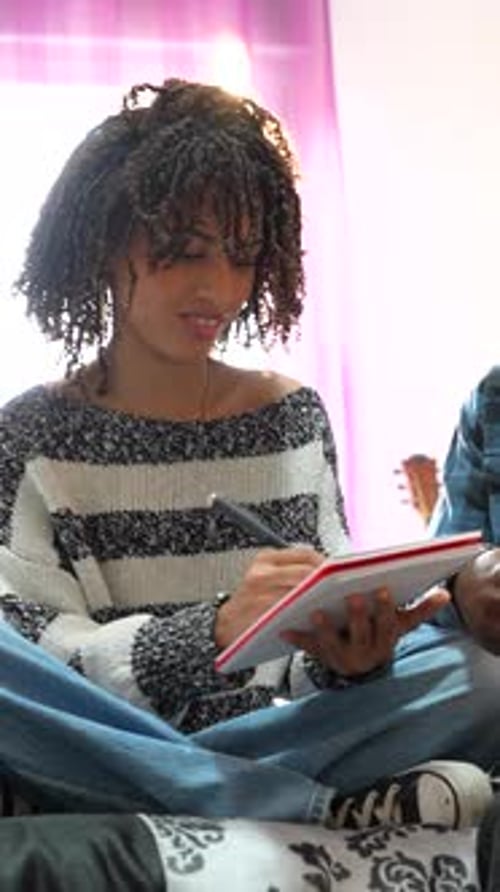 Young Adults Discussing Notebooks Indoors
