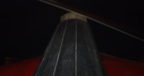 Slow motion artistic macro of master artisan luthier playing with a bow on a handmade violin or ce