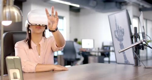 Using VR headset, woman interacting with virtual interface in modern office, copy space